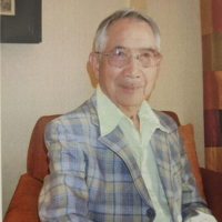 An older man with glasses smiling